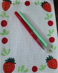 a red pen sitting on top of a piece of paper with strawberries drawn on it