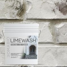 a white brick wall with an advertisement on it that says limewash next to the door