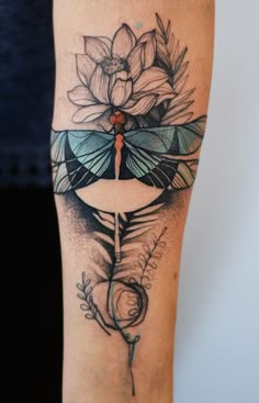 a woman's arm with a dragon and flower tattoo on it