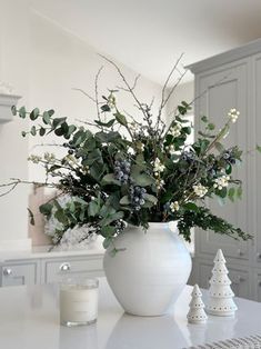 a white vase filled with flowers on top of a counter