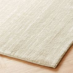 a white rug on top of a wooden floor next to a wood flooring board