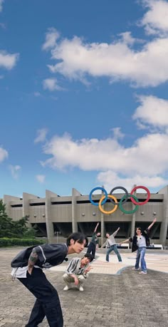 two men are doing tricks in front of the olympic rings