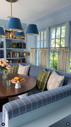 a living room filled with furniture and a wooden table topped with fruit on top of it