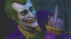 the joker is making a peace sign with his hand