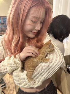 a woman holding a cat in her arms