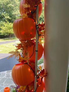 pumpkins are hanging from the side of a pole