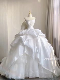 a white wedding dress on display in front of a window