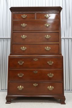 an antique chest of drawers with brass handles