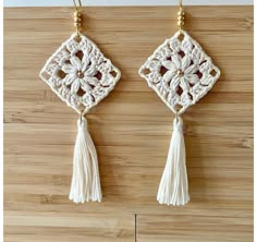 two crocheted wall hangings with tassels and beads on wooden background