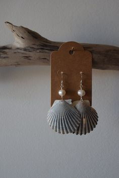 No two shells are alike and that's what makes these earrings so special. These scallop shells were found off the beaches of CT & RI. Paired with pearls, these scallop shells make the perfect set.  Made with silver coated brass & copper wire, plastic pearls & sterling silver earring wires. All shells are found, properly cleaned & up cycled.  Each purchase is packaged in a 100% recycled jewelry box, a 100% recycled padded mailer, 100% recycled tissue paper & hemp twine. Handmade Shell-shaped Pearl Earrings For Gifts, Handmade Shell Pearl Earrings For Gift, Ocean-inspired Pearl Drop Earrings, Shell-shaped Shell Earrings With Ear Wire, Shell-shaped Pearl Charm Earrings As Gift, Nickel-free Shell Dangle Earrings, Shell-shaped Pearl Earrings For Gift, Handmade Silver Shell-shaped Pearl Earrings, Pearl Drop Shell-shaped Earrings In Mother Of Pearl