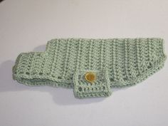 a green crocheted purse with a button on it