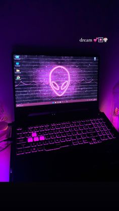 an alien head on the screen of a laptop computer in purple light with wires and plugs