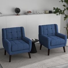 two blue chairs sitting next to each other on top of a carpeted floor in front of a white wall