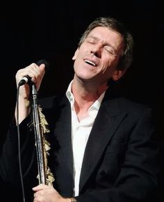 a man in a suit singing into a microphone