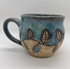 a blue and brown cup with leaves on it