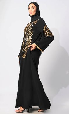 Introducing our latest marvel from the Eid Collection: the epitome of elegance and craftsmanship, our newly launched Abaya. This exquisite garment seamlessly blends machine embroidery with intricate handcrafted details, creating a masterpiece that exudes sophistication and grace. Crafted with meticulous attention to detail, each stitch of machine embroidery adds a touch of refinement to the garment, enhancing its beauty and allure. Meanwhile, handcrafted elements further elevate the abaya, showcasing the skillful artistry of our craftsmen. The combination of machine embroidery and handcrafted details results in a unique and captivating design that is perfect for Eid celebrations and special occasions. Whether you're attending a festive gathering or hosting a family dinner, this abaya promi Formal Embroidered Long Sleeve Thobe, Formal Abaya With Dabka Work For Eid, Formal Eid Abaya With Dabka Work, Festive Long Sleeve Abaya With Dabka, Long Sleeve Sets With Gold Embroidery For Eid, Fitted Long Sleeve Abaya With Dabka Work, Traditional Long Sleeve Embroidered Khimar, Black Abaya With Dabka Work, Traditional Embroidered Long Sleeve Khimar