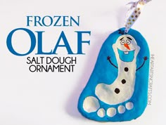 a blue and white snowman ornament hanging from a string with the words frozen olaf on it