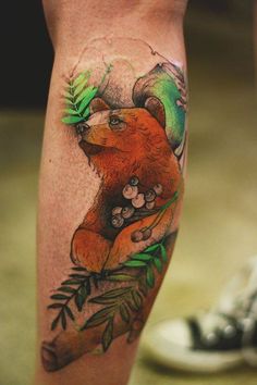 a bear with leaves and berries on it's legs is shown in this tattoo design