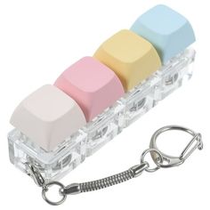 four erasers in a plastic case with key chain attached to it's side