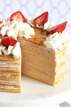 a stack of pancakes topped with strawberries and whipped cream