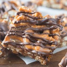 a stack of chocolate covered donuts sitting on top of a wooden table