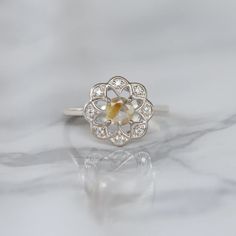 Sometimes when a girl says she likes to receive flowers as a gift, it's not the real flowers she means. Think twice and go for the safest thing - our Flora ring with Golden Rutile Ring with Moissanite. Floral jewelry is where it's at! Perfect as a graduation gift, birthday gift, anniversary ring, or a promise ring. Det Diamond White Flower Ring With Round Cut For Gift, Rose Cut Diamond Birthstone Ring, Diamond White Round Cut Flower Ring Gift, Diamond White Flower Ring Gift, Gift Diamond White Flower Ring, Flower Shaped Cluster Ring Gemstone For Promise, Promise Flower Ring With Rose Cut Diamonds, Promise Rose Cut Diamond Flower Ring, Heirloom Flower Ring With Rose Cut Diamonds As Gift