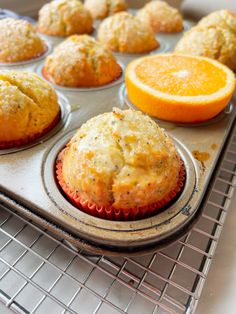 muffins with orange slices in the background on a cooling rack