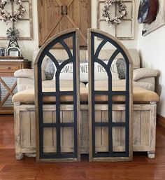 a pair of arched mirrors sitting on top of a wooden floor next to a couch