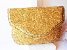 "Dazzling vintage Magid gold evening bag. This glamorous bag is a gold beaded bag. It has a mix of gold micro beads and gold iridescent beads. It really sparkles. The interior of the bag is gold satin and it contains one pocket. This is a beaded clutch bag and it has a snap closure. A very glamorous gold handbag. MATERIAL: Beading, satin CONDITION: It is in good condition SIZE: It measures 8\" wide and 6\" high COLOR: Gold" Gold Sequined Bags As Gifts, Gold Sequined Bags For Gifts, Gold Sequin Bags For Gifts, Yellow Luxury Clutch Evening Bag For Party, Yellow Clutch Evening Bag For Party, Gold Beaded Bag For Festive Occasions, Festive Gold Bag With Gold Beads, Gold Sequined Rectangular Evening Bag, Gold Sequined Clutch Evening Bag