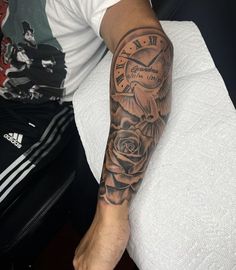 a man's arm with a clock and rose tattoo on the left side of his arm