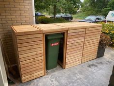 there is a large wooden box next to the trash can