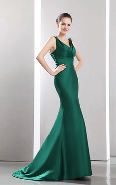 a woman in a long green dress posing for the camera with her hands on her hips