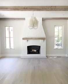 an empty living room with white walls and wood floors