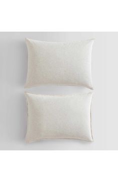 two white pillows sitting next to each other