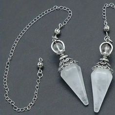 two white crystal pendulums on a chain