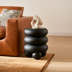 a living room with a leather chair and stack of rocks on the floor next to it