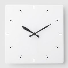 a white square clock with black numbers on the face