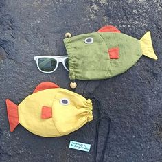 two stuffed fish with sunglasses on the ground