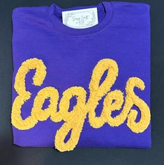 an eagle's t - shirt with the word eagles written in yellow on it