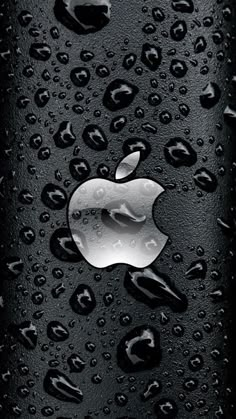 an apple logo is shown on the side of a black surface with water droplets around it