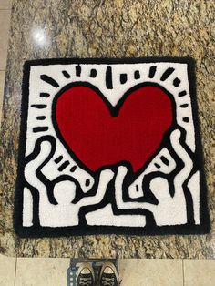 a pair of shoes sitting on top of a floor next to a rug with a heart