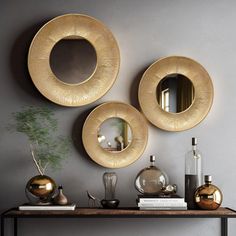 three round mirrors on the wall above a table