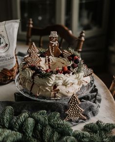 a christmas cake sitting on top of a table next to pine cones and other decorations