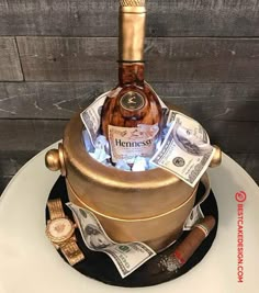 a cake with money and a bottle on top