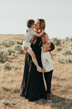 a mother and her two sons kissing in the desert