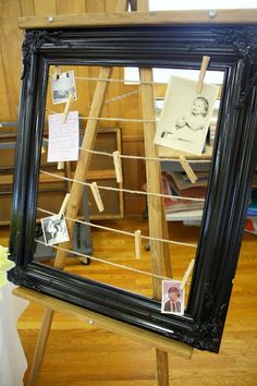 a black framed mirror sitting on top of a wooden table