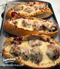 three breads with meatballs and cheese on them in a baking pan, ready to be baked