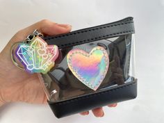 "Cute keychain pouch to keep your crystals (or other items) from getting lost in your purse, bag, backpack, etc. Approximate Dimensions: 3.5\" H x 4.5\" L x 2\" W 💖I have a crystal for that💖 -clear vinyl front -holo faux leather heart patch -black faux leather -silver keychain -glitter rainbow resin charm 📷 Check out our instagram @little.rainbow.factory for more pictures/videos of this item Please note... This product is handmade with love. Resin charms may have minor imperfections (such as Compact Black Bag As Gift, Black Rectangular Coin Purse Gift, Black Bag With Key Clip As Gift, Compact Black Bag For Gift, Black Rectangular Keychain Perfect For Gifts, Resin Bag Charm, Black Rectangular Keychain For Gift, Compact Black Gift Bag, Resin Pocket Hearts