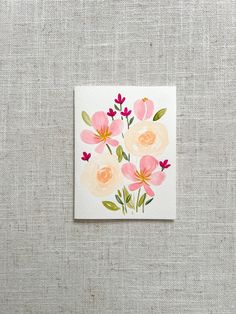 a card with pink and yellow flowers on white paper next to a gray wallpaper