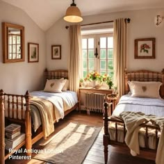 two twin beds in a bedroom with wooden floors and white walls, along with windows that look out onto the outdoors